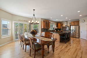 Dining space with light wood-style floors, a wealth of natural light, recessed lighting, and a notable chandelier
