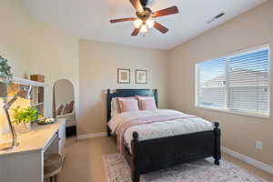 Bedroom with baseboards, visible vents, ceiling fan, and light colored carpet