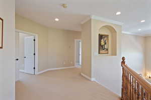 Corridor with crown molding, light carpet, recessed lighting, and an upstairs landing