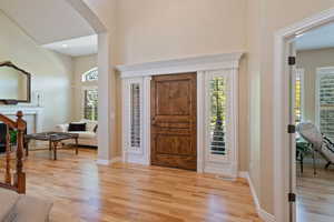 Entryway with a healthy amount of sunlight, arched walkways, light wood-type flooring, and visible vents