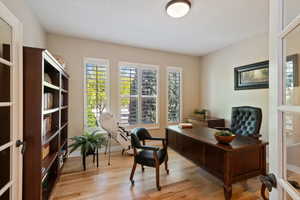 Office area featuring baseboards, plenty of natural light, and light wood-style floors