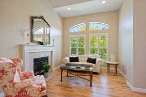 Living room featuring recessed lighting, baseboards, a tiled fireplace, and light wood finished floors