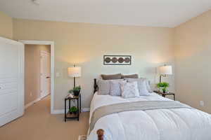 Bedroom featuring baseboards and light colored carpet