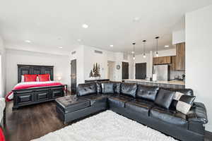 Living room with recessed lighting, visible vents, and dark wood-style floors