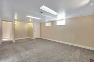 Basement with visible vents and carpet flooring