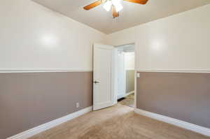 Unfurnished room with baseboards, a ceiling fan, and carpet