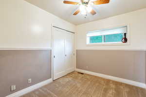 Unfurnished bedroom with ceiling fan, light carpet, baseboards, visible vents, and a closet