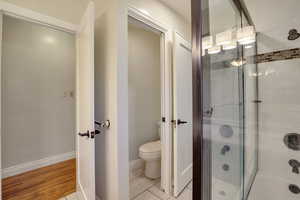 Bathroom with baseboards, toilet, and wood finished floors