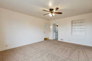 Unfurnished room featuring a ceiling fan, baseboards, visible vents, and light carpet