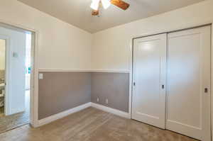 Unfurnished bedroom featuring a ceiling fan, baseboards, light carpet, and a closet