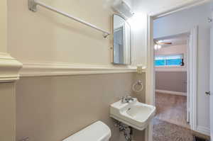 Bathroom featuring toilet, a ceiling fan, visible vents, and a sink