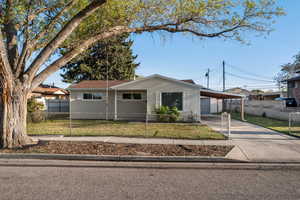 View of front facade with concrete driveway, a fenced front yard, and a front lawn