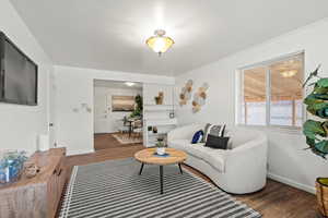 Living room featuring baseboards, ornamental molding, and wood finished floors