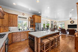 Kitchen with a sink, a center island, stainless steel appliances, and a wealth of natural light