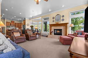 Carpeted living room featuring crown molding, recessed lighting, and a wealth of natural light
