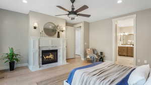 Bedroom featuring recessed lighting, baseboards, wood finished floors, and a high end fireplace