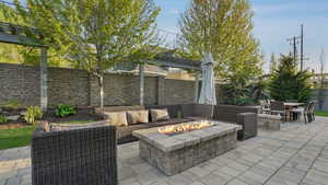 View of patio / terrace featuring a fenced backyard, an outdoor living space with a fire pit, a pergola, and outdoor dining area