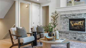 Living area featuring a stone fireplace and wood finished floors