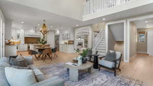 Living area featuring stairway, recessed lighting, light wood-style flooring, and a notable chandelier