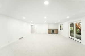 Interior space with visible vents, recessed lighting, baseboards, and light carpet