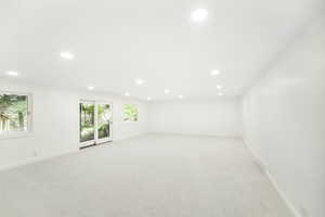 Spare room with baseboards, light carpet, and recessed lighting