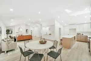 Dining area with light wood-type flooring, recessed lighting, and vaulted ceiling
