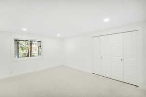 Unfurnished bedroom featuring light colored carpet, recessed lighting, baseboards, and a closet