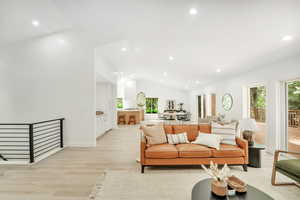 Living room with light wood-type flooring, vaulted ceiling, and recessed lighting