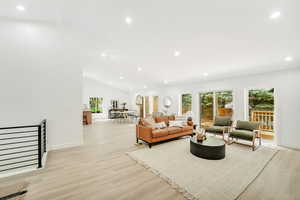 Living area featuring recessed lighting, light wood finished floors, baseboards, and vaulted ceiling