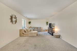 Carpeted living room featuring baseboards