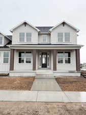 View of front of property with roof with shingles and covered porch