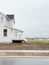 Exterior space with roof with shingles and a deck