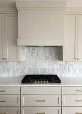 Kitchen featuring premium range hood, light countertops, tasteful backsplash, and stainless steel gas stovetop