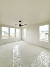 Empty room with baseboards, a ceiling fan, visible vents, and carpet