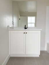 Full bath with a bath, baseboards, visible vents, and vanity