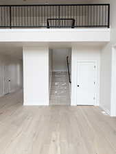 Stairway with wood finished floors, a high ceiling, and baseboards