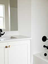 Bathroom with vanity and bathing tub / shower combination
