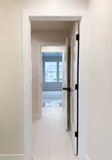 Hallway with baseboards and light tile patterned floors