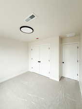 Unfurnished bedroom featuring baseboards, a closet, visible vents, and carpet