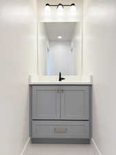 Bathroom with vanity, tile patterned floors, and baseboards
