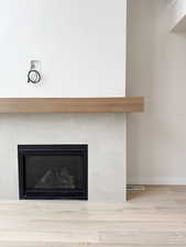 Interior details featuring a fireplace, wood finished floors, visible vents, and baseboards
