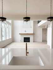 Unfurnished living room featuring a glass covered fireplace, a textured ceiling, a ceiling fan, and a sink