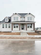 Townhome / multi-family property featuring board and batten siding, roof with shingles, and a porch