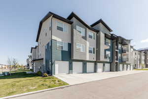 Exterior space featuring a garage, driveway, and cooling unit