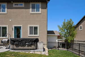 Rear view of property with stucco siding and fence