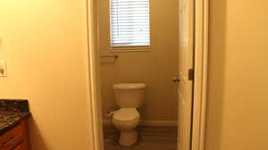 Bathroom featuring vanity, baseboards, and toilet