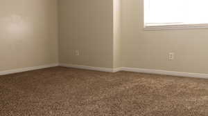 Carpeted empty room with baseboards