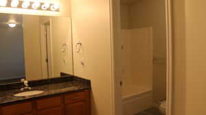 Full bath with vanity, bathtub / shower combination, and toilet