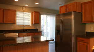 Kitchen with stainless steel refrigerator with ice dispenser, a sink, plenty of natural light, and dishwasher