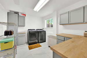 Laundry room with tile floor, cabinet space, and washing machine and dryer